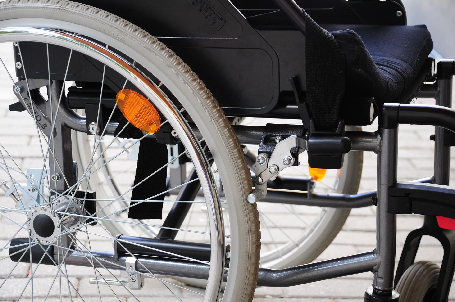 Een grijs wiel van een rolstoel.